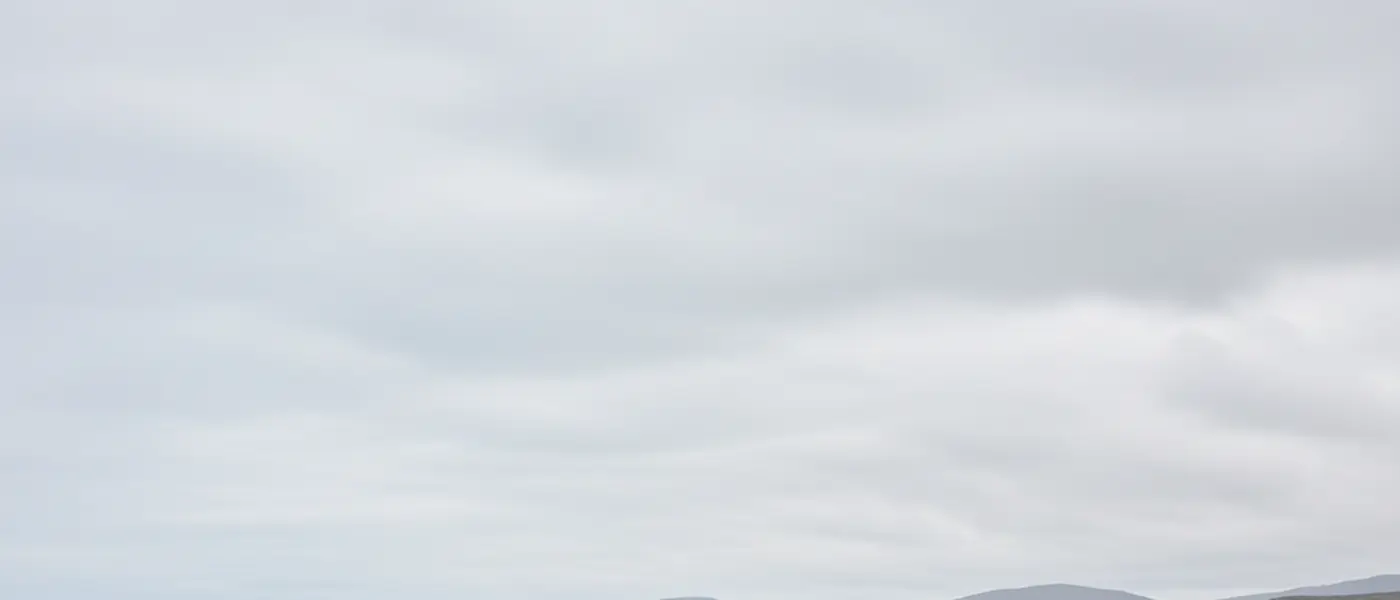 Peaceful protesters near a military base fence in Scotland, grey coastal sky